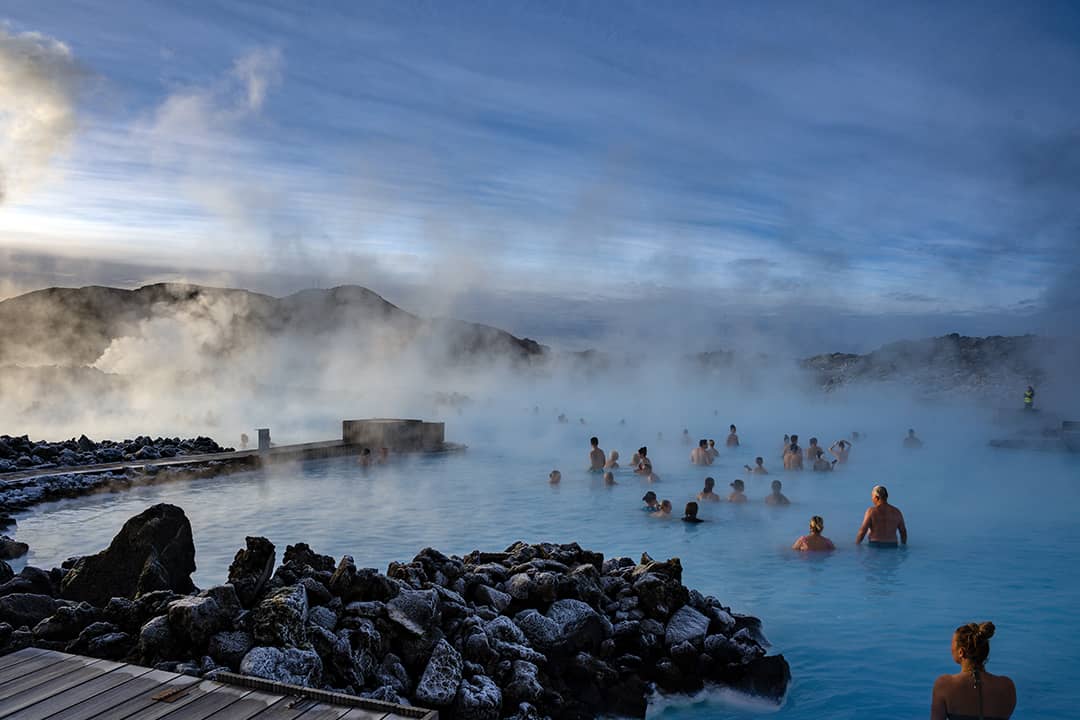People swimming in the Blue Lagoon geothermal spa during winter in Grindavík, Iceland.